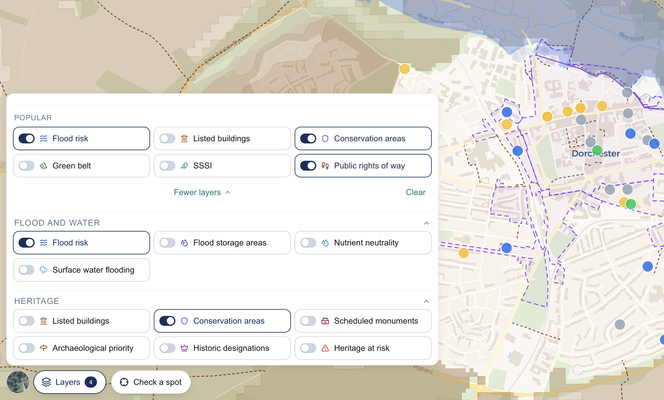 The Layers panel open on a map of Bath with five switches on: flood risk, listed buildings, conservation areas, national landscapes and tree preservation, each drawn on the map behind the panel.